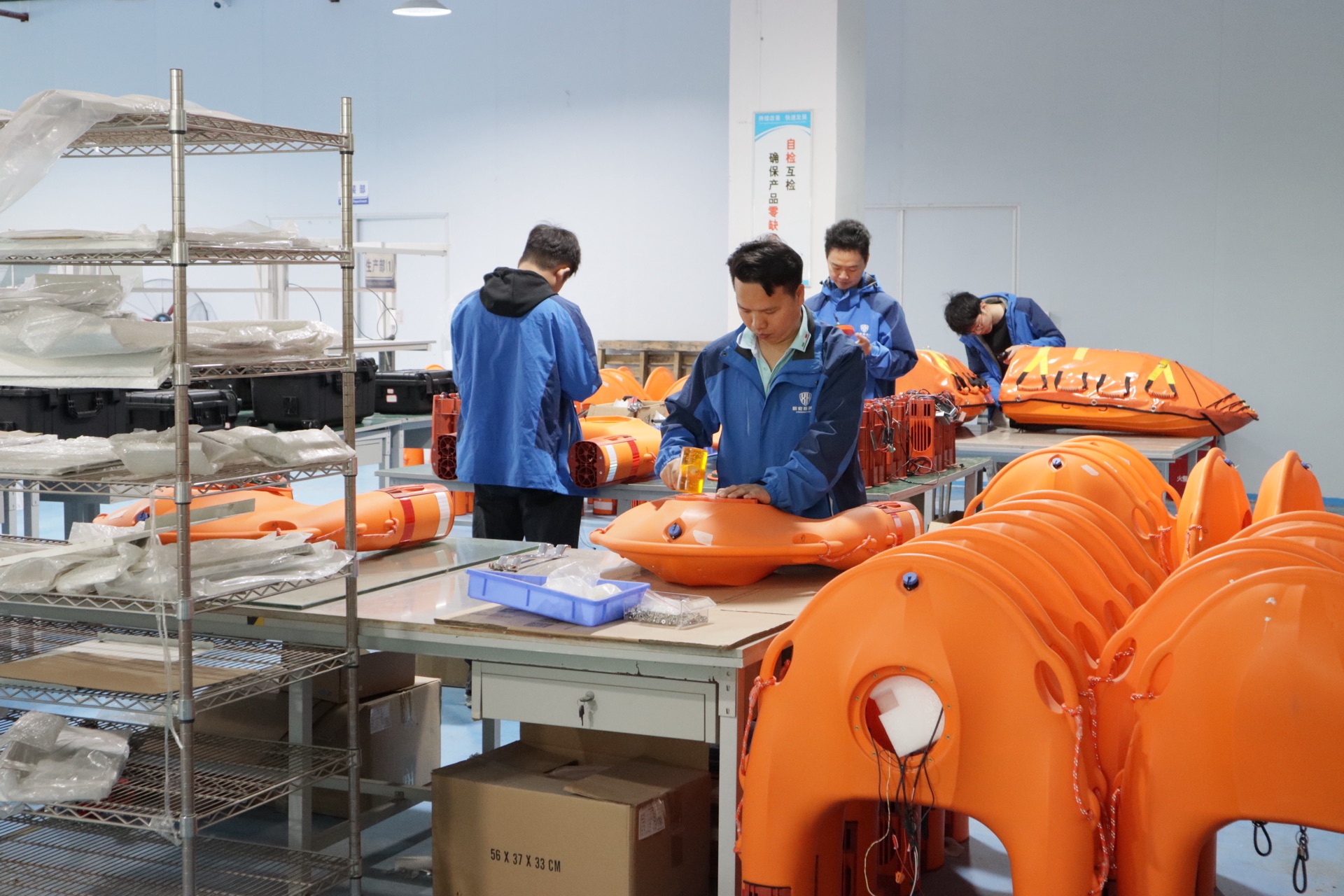 Quality control inspection team checking rescue craft components before shipping